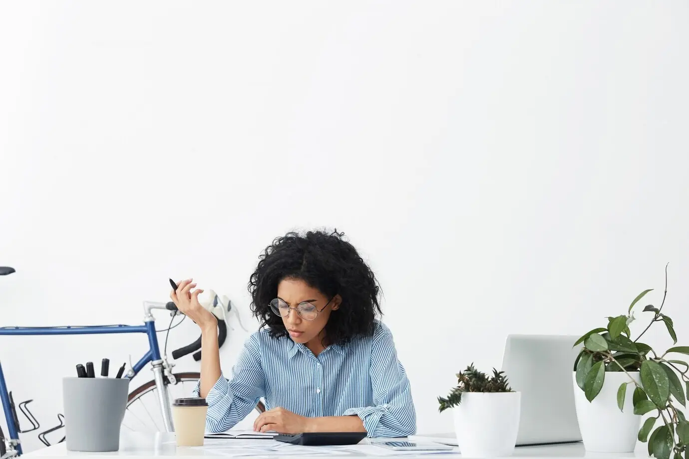 Сосредоточенная молодая темнокожая женщина-бухгалтер составляет отчет.